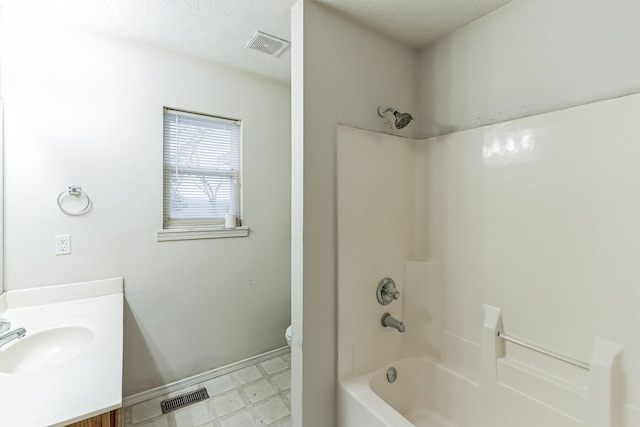 full bathroom featuring vanity, toilet, a textured ceiling, and shower / bathtub combination