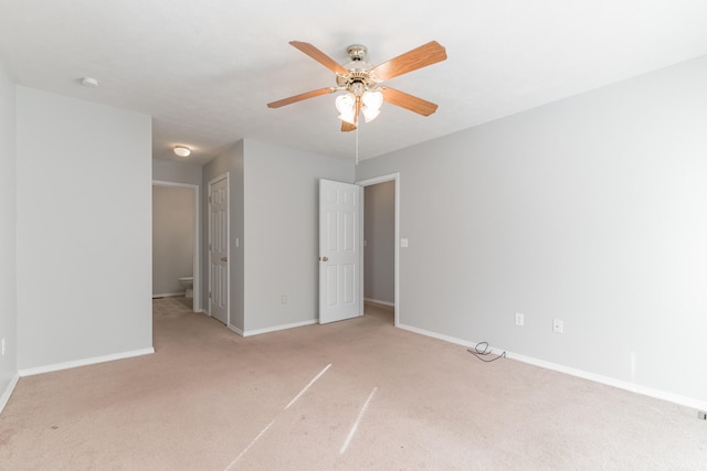 unfurnished bedroom featuring light carpet, ceiling fan, and ensuite bathroom