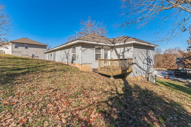 view of side of property featuring a wooden deck and a lawn