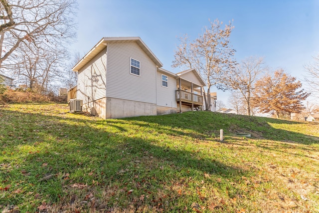 back of house featuring cooling unit, a yard, and a wooden deck