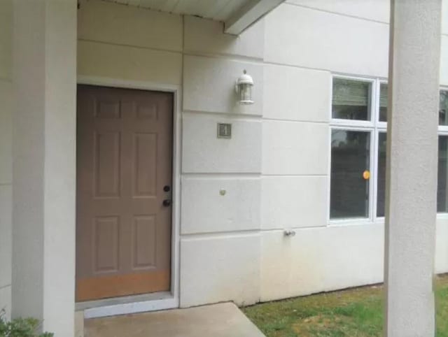 entrance to property with stucco siding