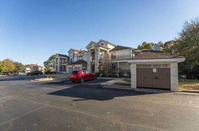 traditional-style house featuring uncovered parking, a chimney, and a residential view