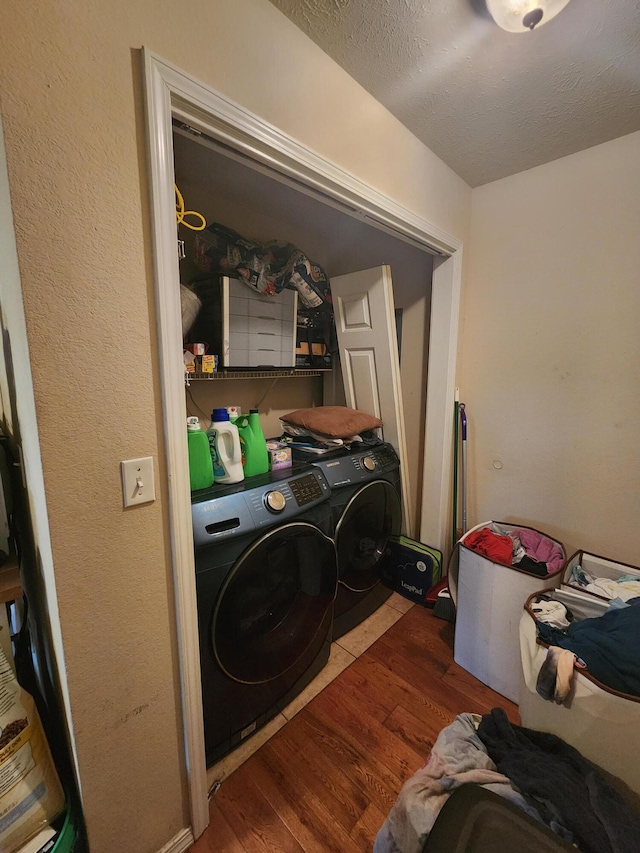 laundry room with a textured ceiling, dark wood-type flooring, and washing machine and dryer