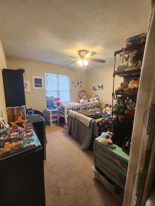 carpeted bedroom featuring ceiling fan and a textured ceiling