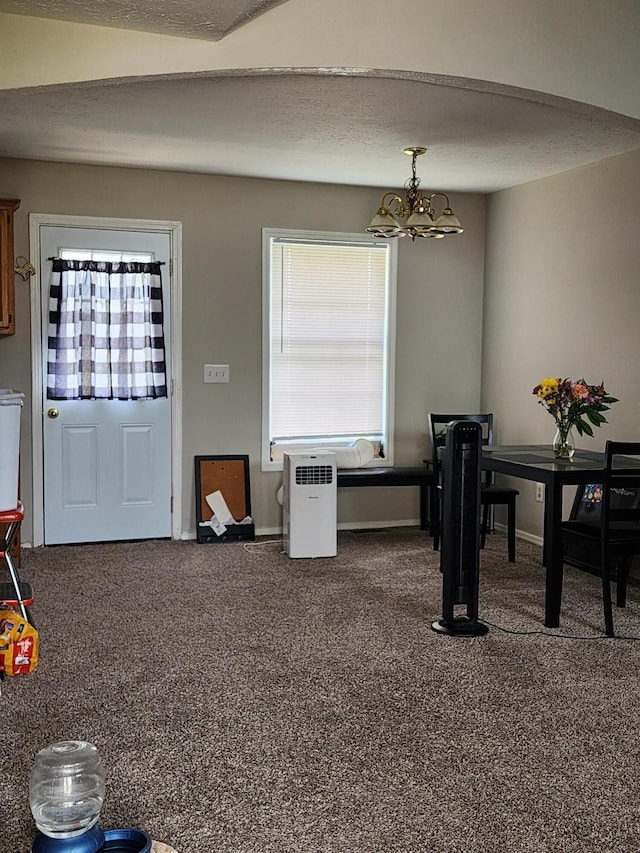 carpeted dining space with a textured ceiling