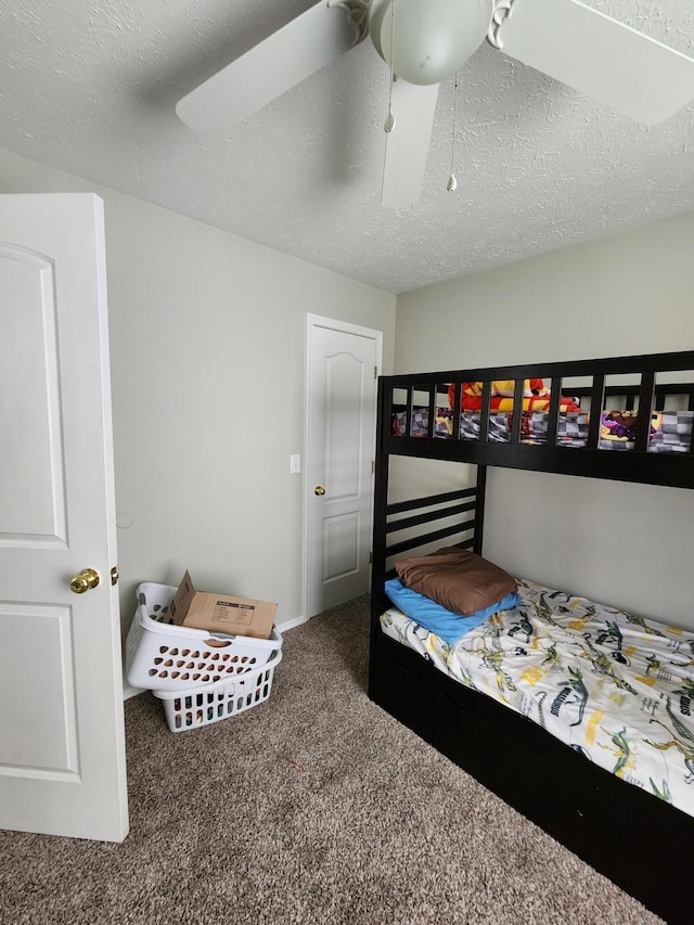 carpeted bedroom with a textured ceiling and ceiling fan