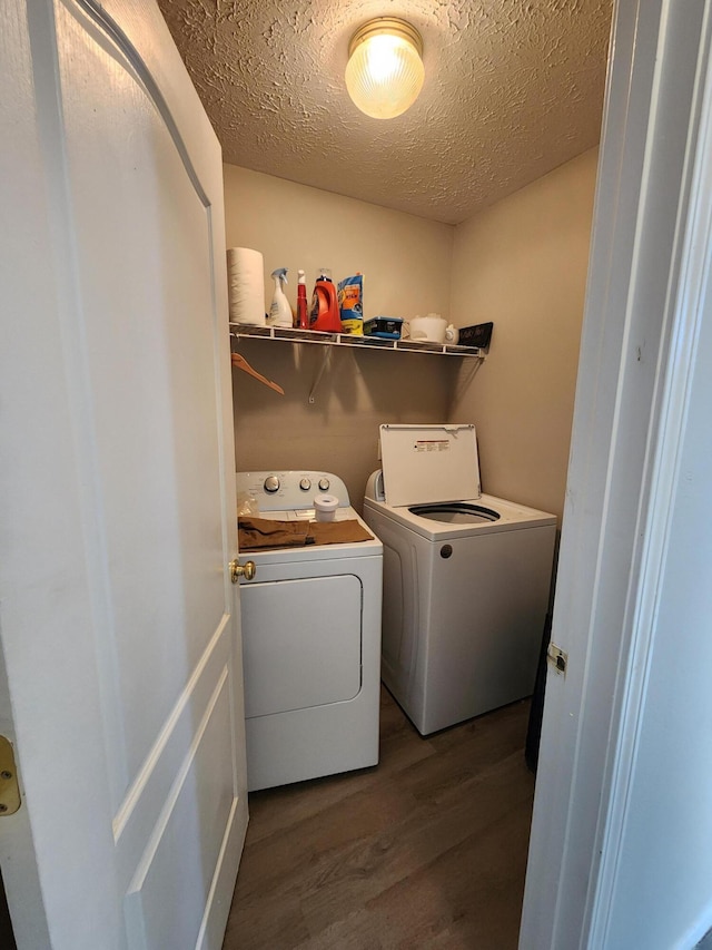 1213 Woodland, Monett, MO 65708 - clothes washing area with a textured ceiling, wood finished floors, washer and dryer, and laundry area