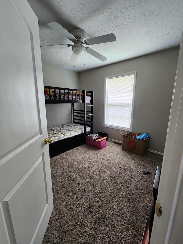 bedroom with a textured ceiling, ceiling fan, and carpet flooring