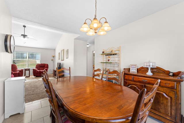 tiled dining space featuring ceiling fan with notable chandelier and vaulted ceiling