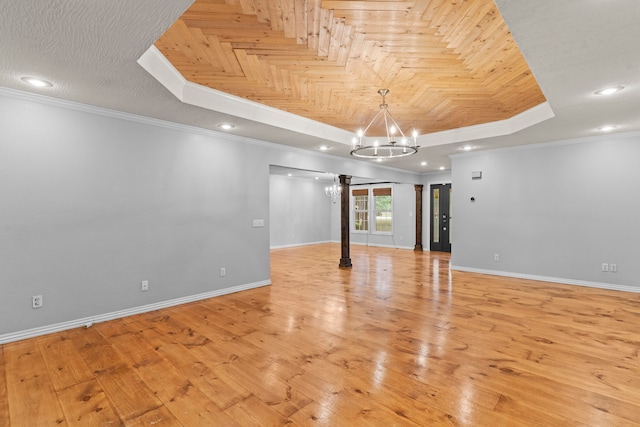 spare room with light wood-type flooring, crown molding, and an inviting chandelier