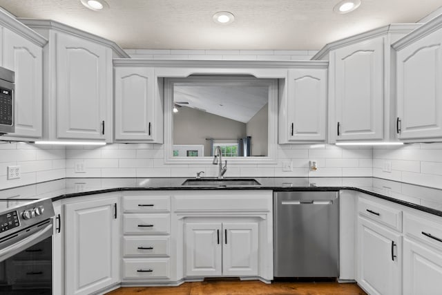 kitchen with stainless steel appliances, white cabinets, and sink