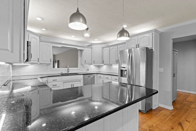 kitchen featuring tasteful backsplash, dark stone counters, decorative light fixtures, sink, and appliances with stainless steel finishes