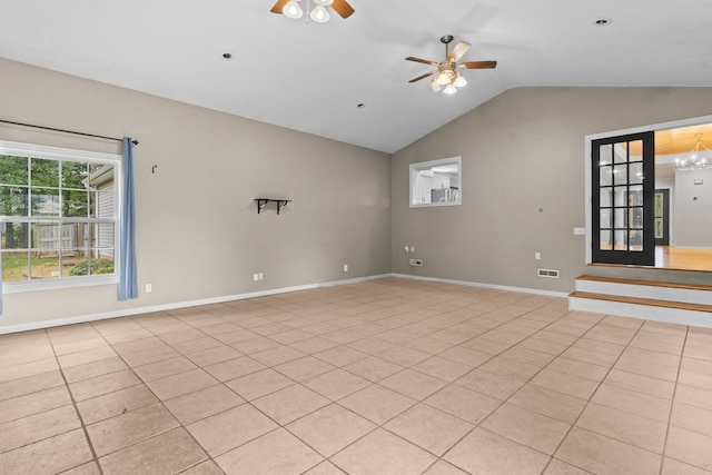 spare room featuring ceiling fan with notable chandelier, lofted ceiling, and light tile patterned floors