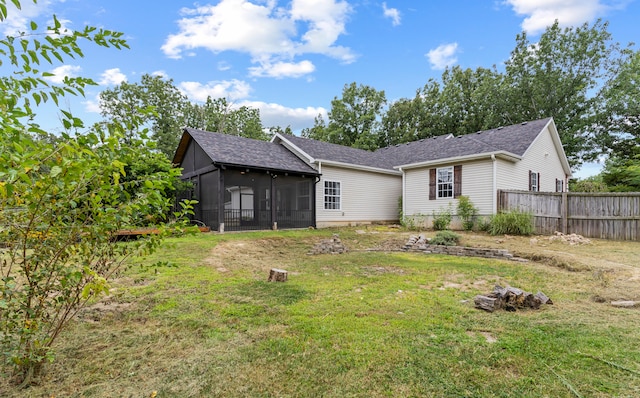 back of property with a sunroom and a yard