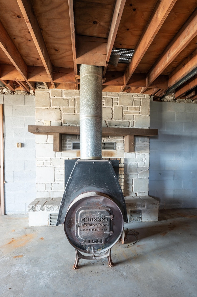 details with concrete flooring and a wood stove