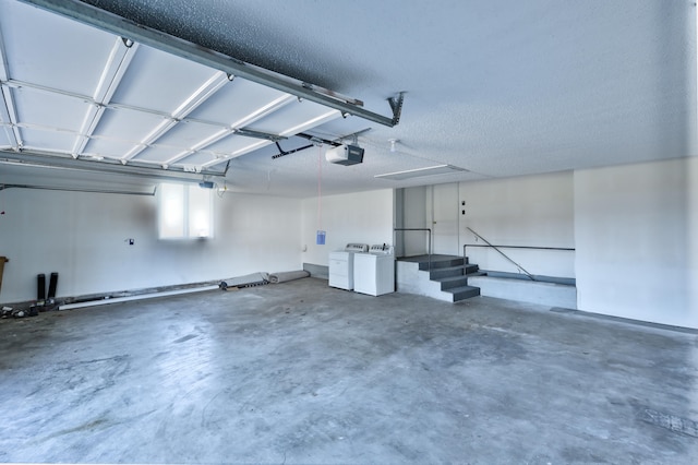 garage with a garage door opener and independent washer and dryer