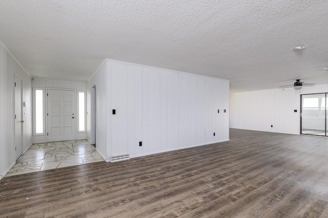 interior space with ornamental molding, dark hardwood / wood-style flooring, a textured ceiling, and ceiling fan