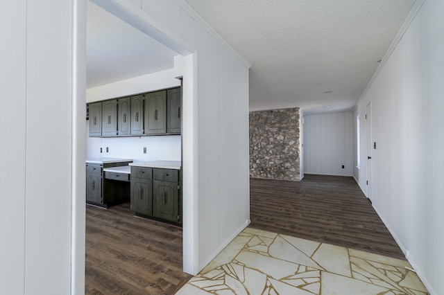 corridor with ornamental molding, hardwood / wood-style flooring, and a textured ceiling