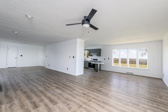 unfurnished living room featuring dark hardwood / wood-style floors, a textured ceiling, and ceiling fan