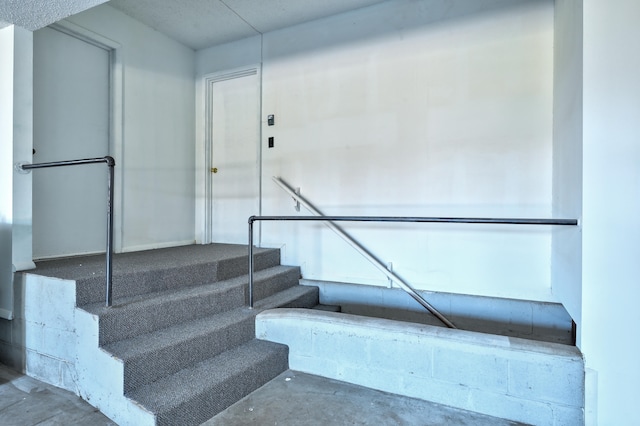 stairs featuring concrete floors