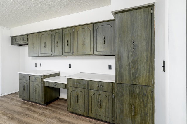 kitchen featuring green cabinets, dark wood-type flooring, and a textured ceiling