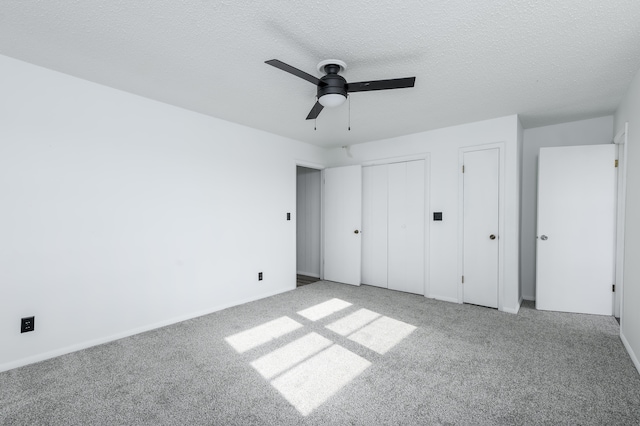 unfurnished bedroom with a textured ceiling, ceiling fan, and light colored carpet