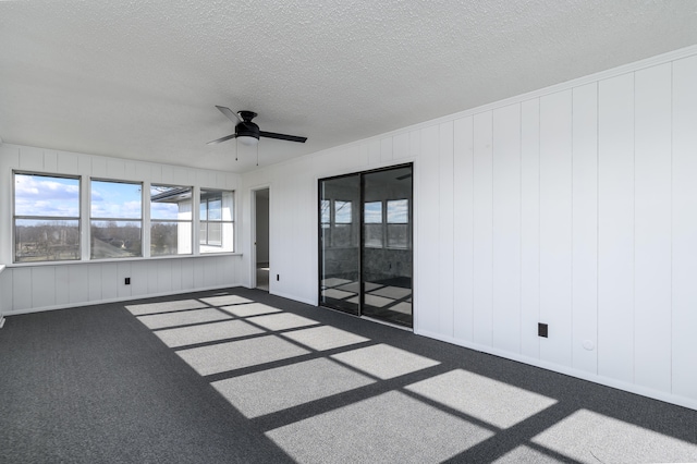 spare room featuring ceiling fan, carpet, and a textured ceiling