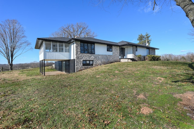 view of front of house with a front yard and a sunroom