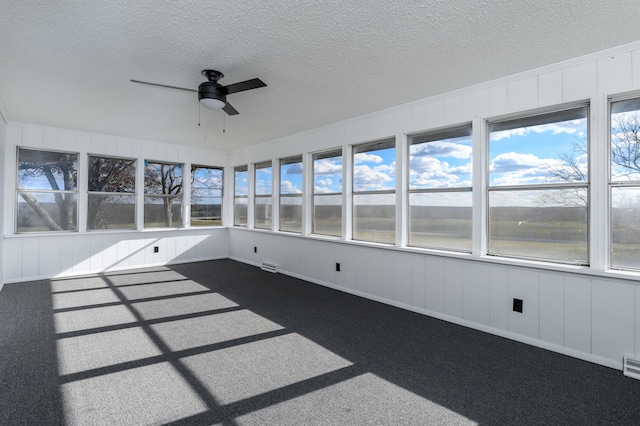 unfurnished sunroom featuring ceiling fan and a wealth of natural light