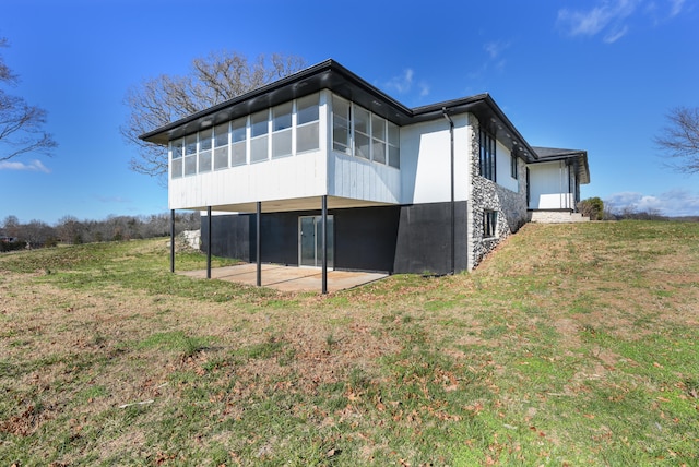 back of house featuring a yard, a sunroom, and a patio area