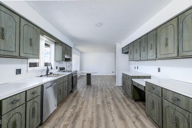 kitchen with light hardwood / wood-style floors, sink, stainless steel appliances, and a textured ceiling