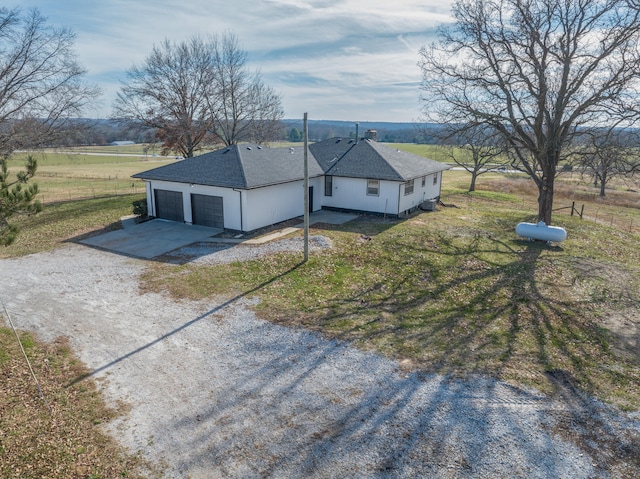 view of front of house featuring a rural view, a front yard, and a garage