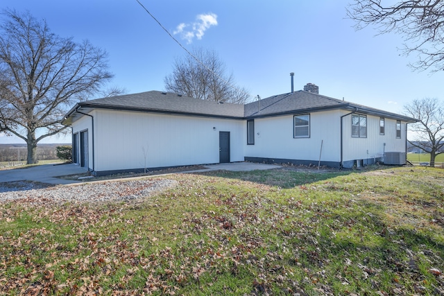 back of property featuring cooling unit and a lawn