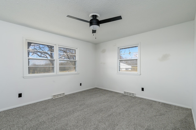 carpeted empty room featuring ceiling fan and a textured ceiling