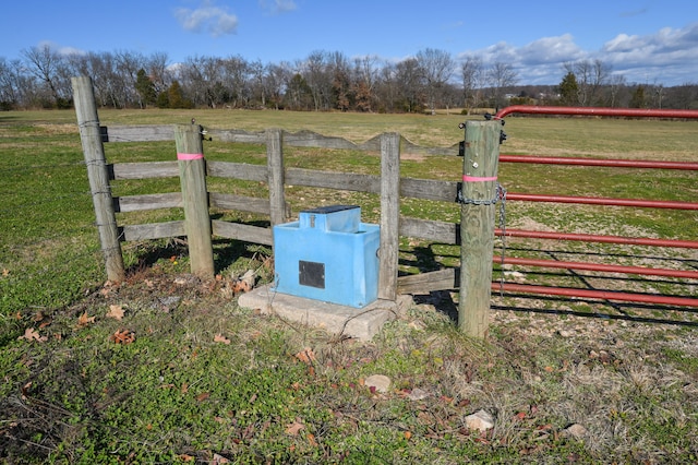 view of gate with a yard and a rural view