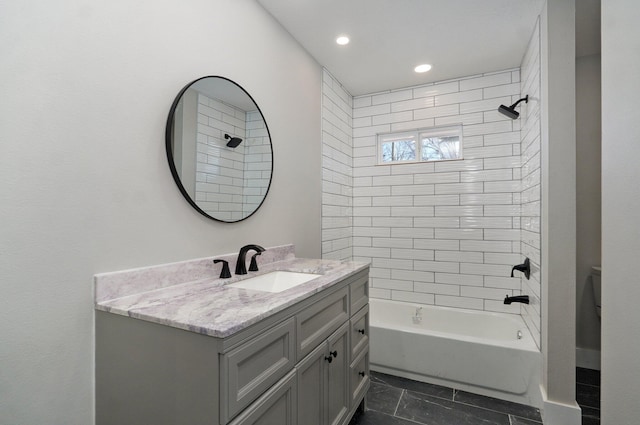 bathroom featuring vanity and tiled shower / bath