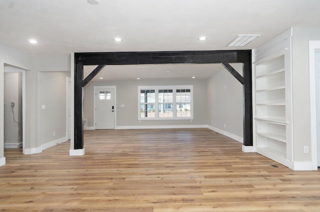 unfurnished living room with light wood-type flooring and a textured ceiling