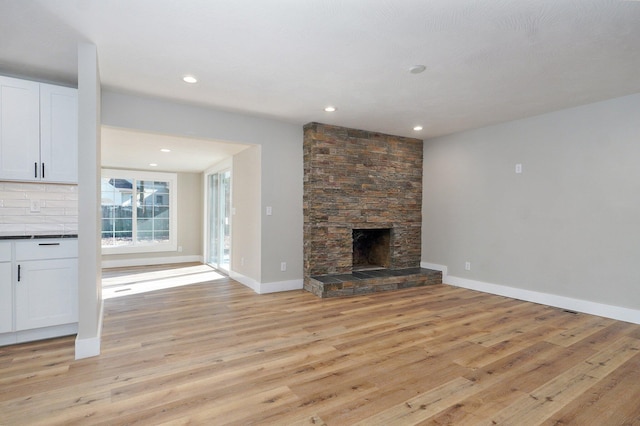 unfurnished living room featuring a fireplace and light hardwood / wood-style flooring