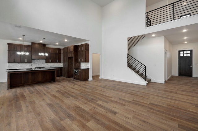 kitchen featuring sink, hanging light fixtures, hardwood / wood-style floors, and a high ceiling