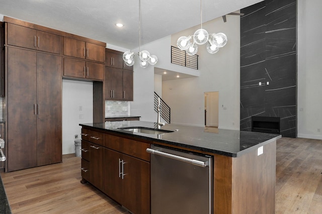 kitchen with dishwasher, decorative light fixtures, light hardwood / wood-style flooring, and sink