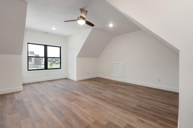 additional living space featuring ceiling fan, vaulted ceiling, hardwood / wood-style floors, and a textured ceiling