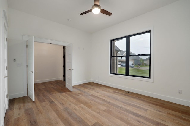 unfurnished room with light wood-type flooring and ceiling fan