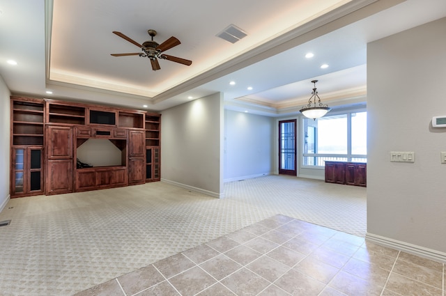 unfurnished living room featuring a raised ceiling, ceiling fan, and light carpet