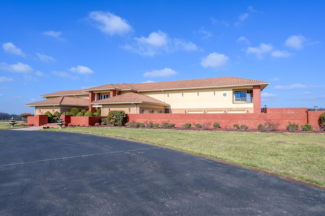 20478 Lawrence Unit 2180, Aurora, MO 65605 - prairie-style home featuring stucco siding, a tiled roof, a front yard, and fence