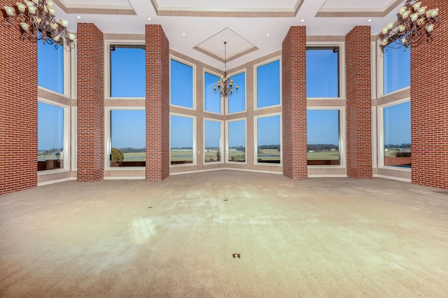 20478 Lawrence Unit 2180, Aurora, MO 65605 - unfurnished living room with an inviting chandelier, carpet flooring, and a towering ceiling