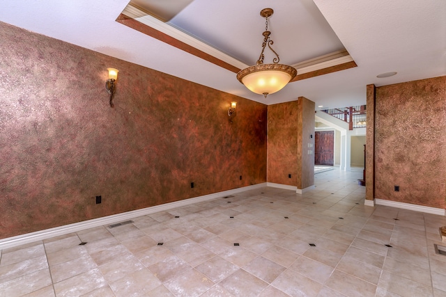 unfurnished room featuring ornamental molding and a tray ceiling