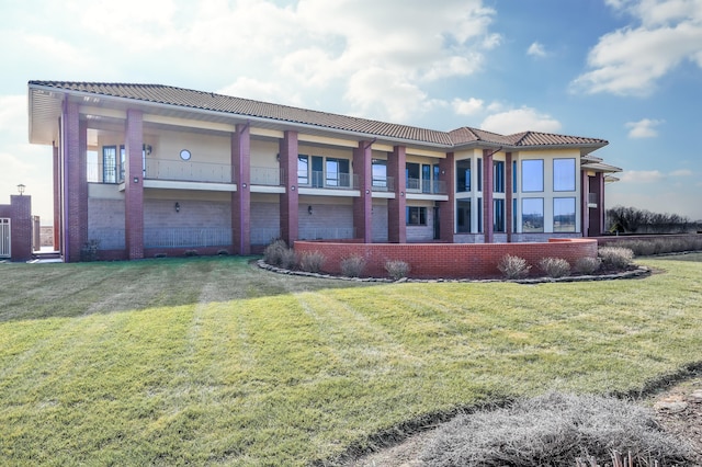 back of house with a balcony and a yard