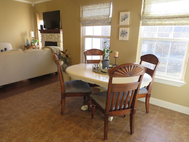 dining area with plenty of natural light and a stone fireplace