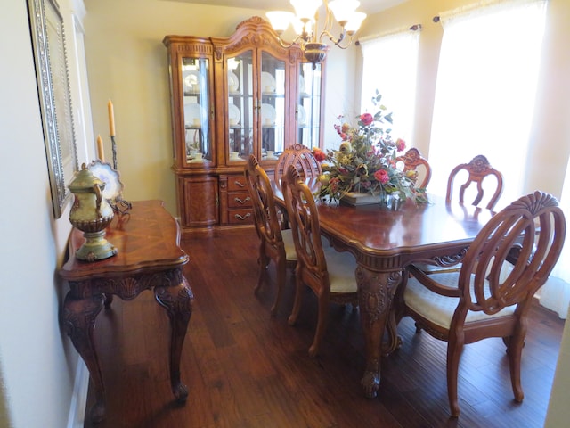 dining space with dark hardwood / wood-style floors and a notable chandelier