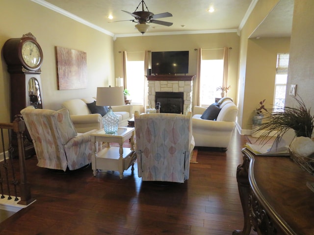 living room with a stone fireplace, ornamental molding, dark hardwood / wood-style floors, and a healthy amount of sunlight